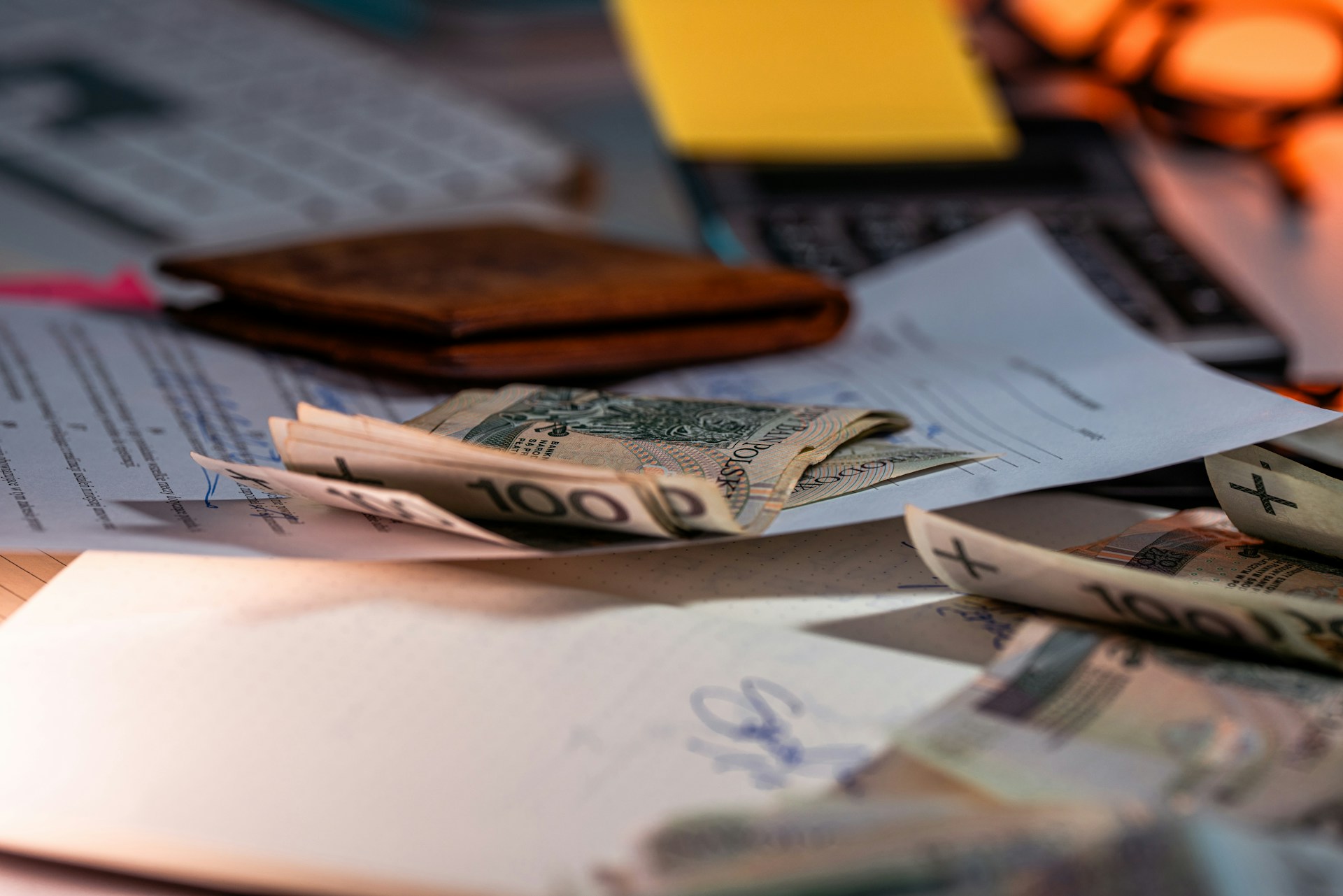 Polskie banknoty, portfel i dokumenty na biurku